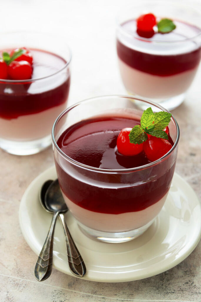 Italian panna cotta dessert with cherry on top in glass. Sweet dessert.