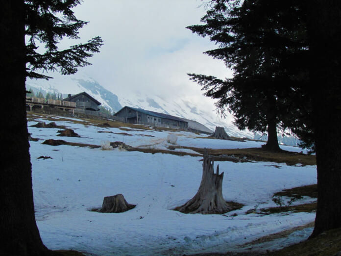 View of mountain hut at Kofce in Karavanke mountains in Gorenjska Slovenia with snow covering the meadow bellow