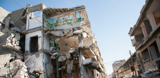 Gaza City, Occupied Palestinian Territories - December 2, 2012: A child passes a bombed-out residential block in the Al-Zeitoun neighborhood of Gaza City.