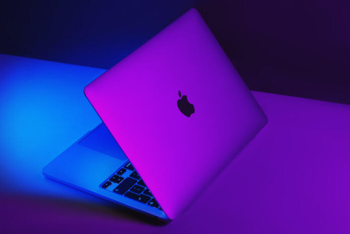 Izmir, Turkey - January 10, 2022: Half opened Apple Brand M1 Model Macbook pro laptop computer with purple and blue colored lights