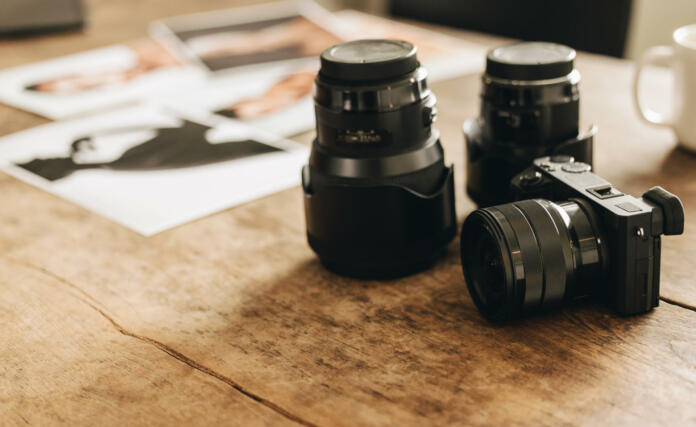 DSLR camera placed on a photographer's desk. Still life shot of a creative workspace in a freelancer's home office.