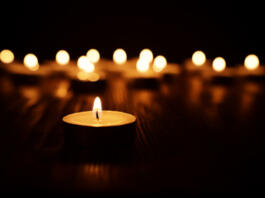 Burning candle over black background