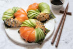 Sushi donuts with salmon avocado and cucumber on a marble table