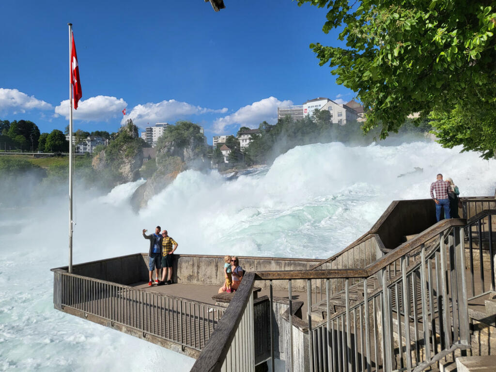 Canton Zurich, Switzerland - 30 MAY 2022 : Tourists enjoying the view of Rhine Falls during sunny summer evening.