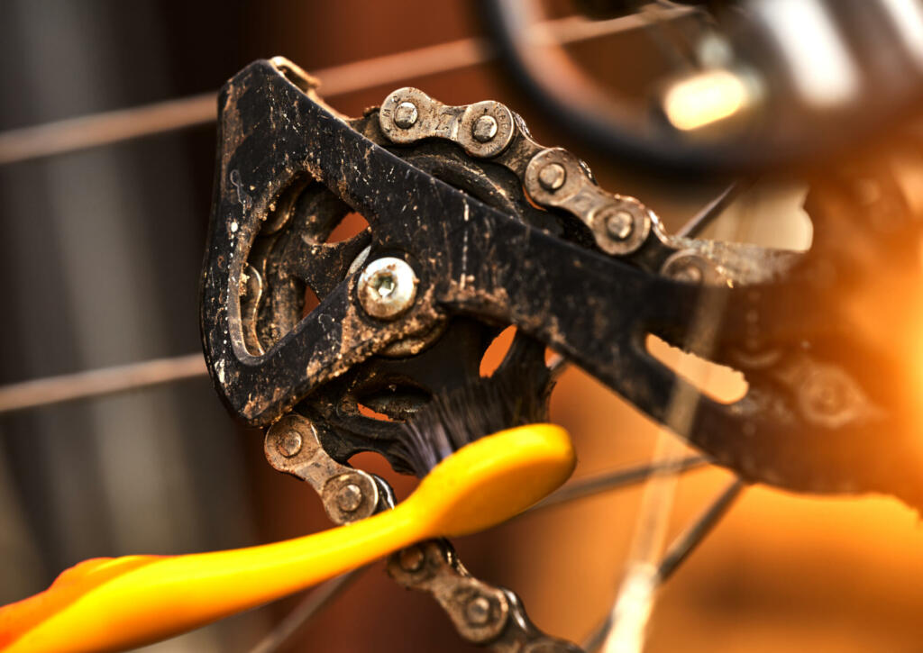 Cleaning the rear sprocket by a toothbrush at on the derailleur of a sporty bicycle with gears
