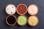 Set of sauces in bowl on stone background