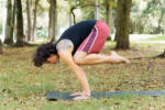 side photo of a man doing yoga bakasana pose in the park amidst nature