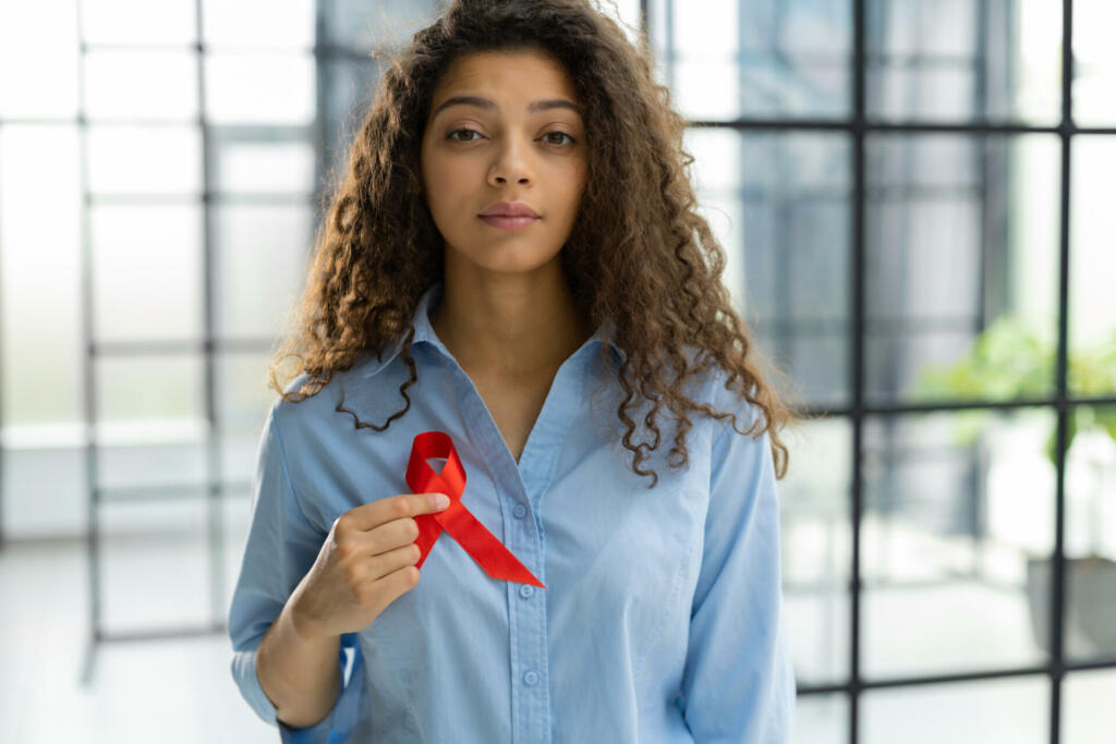 Woman holding red ribbon for december world aids day. Healthcare concept