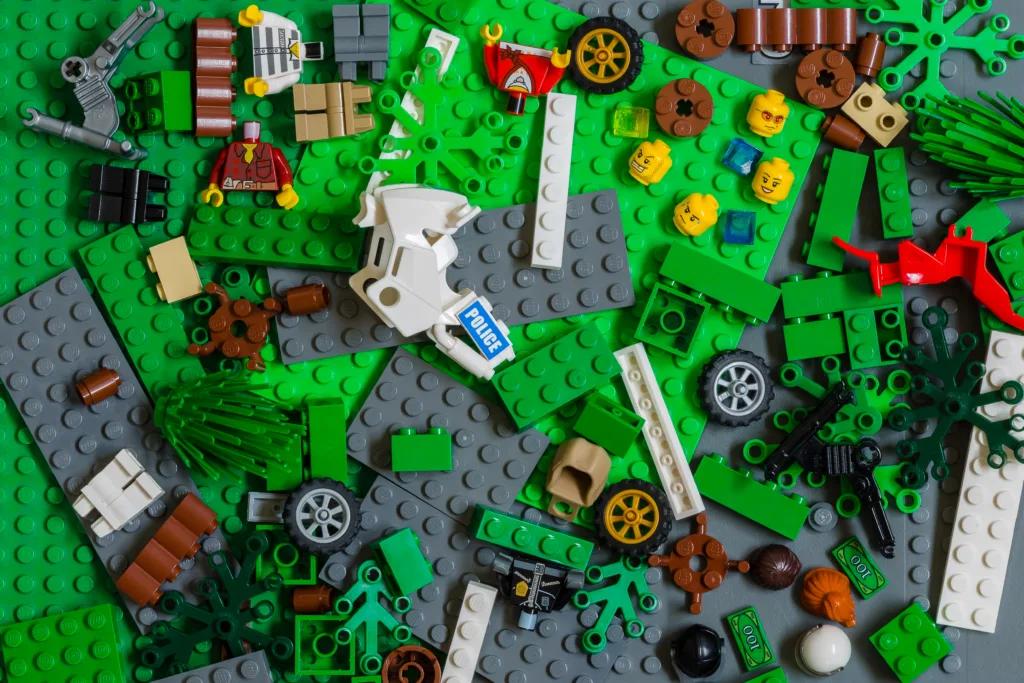 Aalter, Belgium, 21 september 2015: different lego bricks on a lego surface. wheels, heads, body's, trees, colorfull