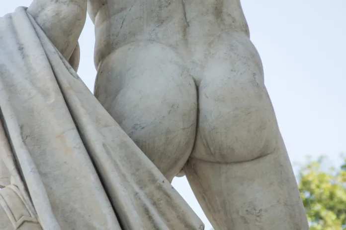 Male buttocks sculpture stone monument close up.
