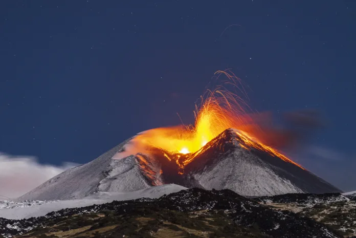 Scenic view of the eruption of the snowy mount (volcano) Etna, south-east crater, at night under full moon, Catania province, Sicily, South of Italy, Italy, Europe