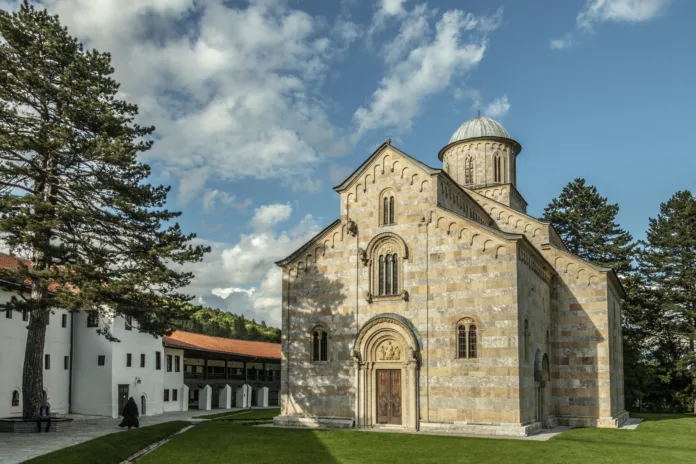 The church has five-nave naos, a three-part iconostasis, and a three-nave parvise. With the dome, it is 26 m high.[citation needed] Its outer walls are done in alternate layers of white and pink marble. The portals, windows, consoles, and capitals are richly decorated. Christ the Judge is shown surrounded by angels in the western part of the church. Its twenty major cycles of fresco murals represent the largest preserved gallery of Serbian medieval art, featuring over 1000 compositions and several thousand portraits.