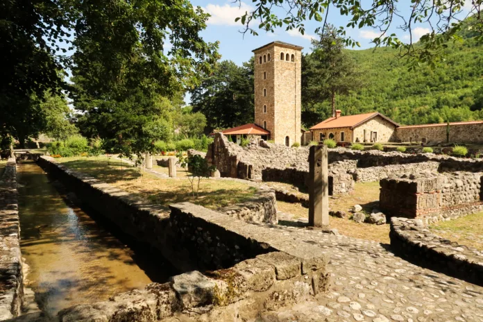 View onto the canal, river, the ruins and the tower, bell tower inside the courtyard, yard, garden of the Patriarchate of Pec Monastery, outside of Peja, Kosovo 2022