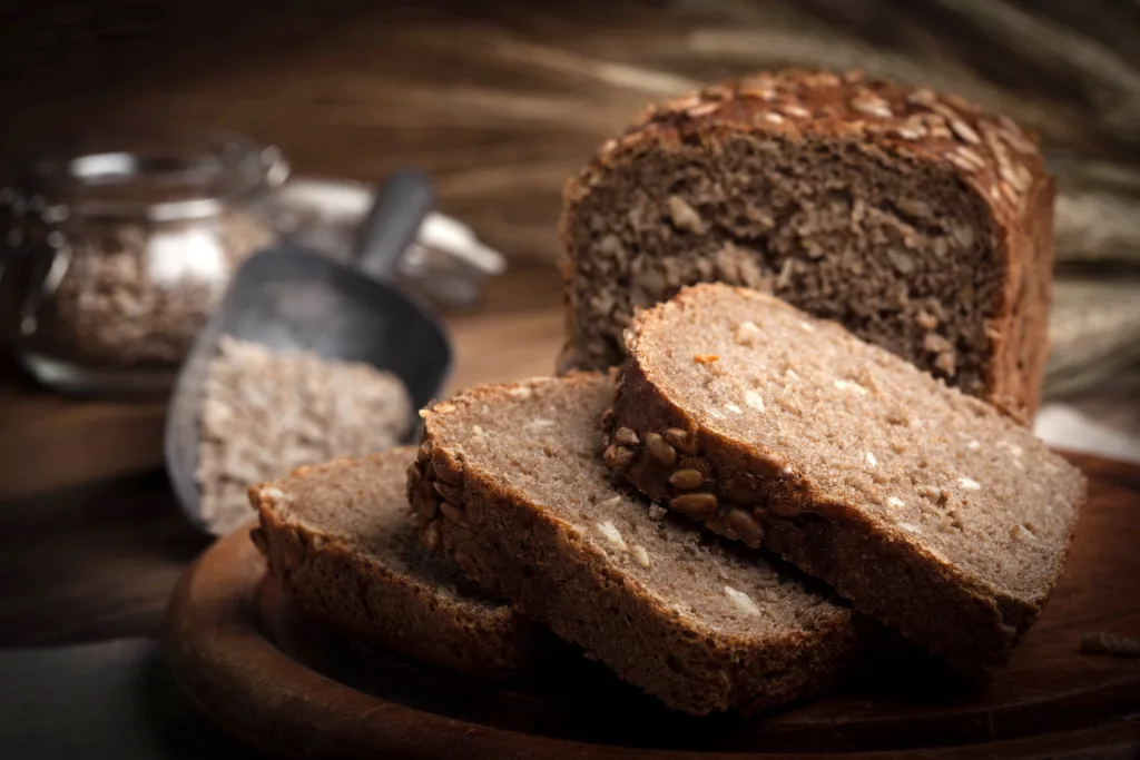 Wholemeal bread with sunflower seeds. Dark light.