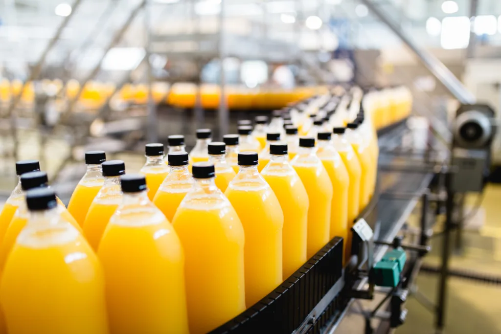 Bottling factory - Orange juice bottling line for processing and bottling juice into bottles. Selective focus.