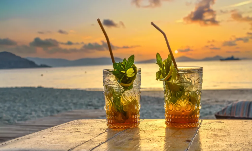 drinks with blur beach and sunset in background