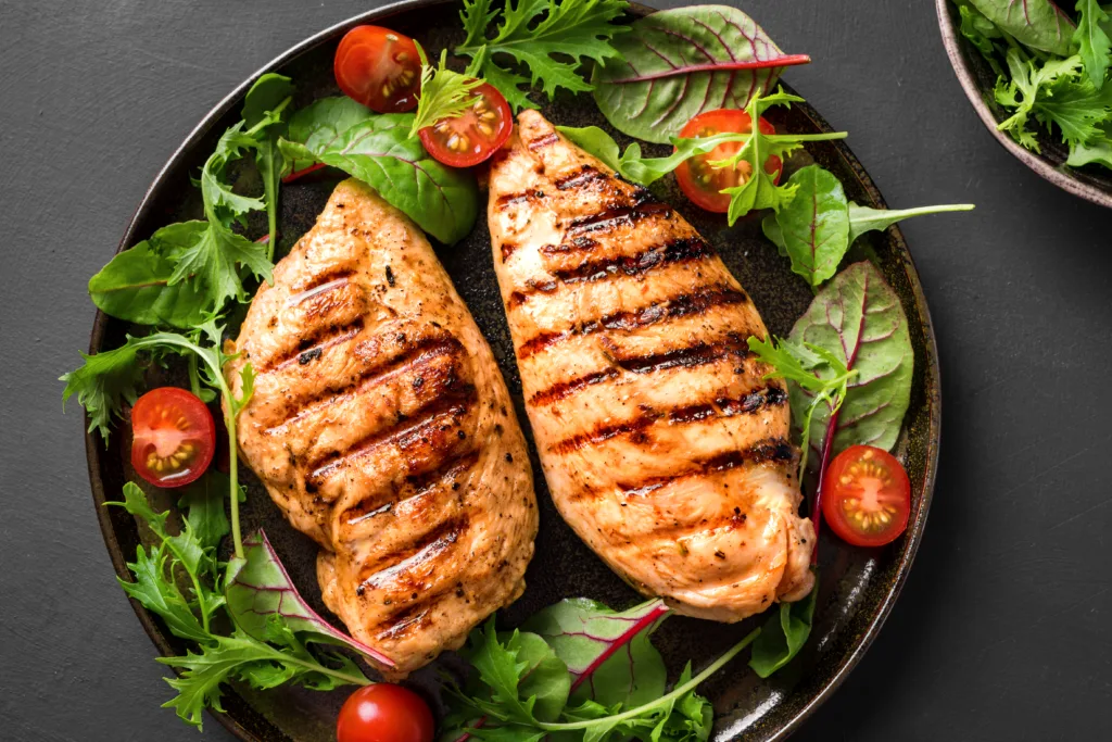 Grilled chicken breast, fillet, steak and fresh vegetable salad. Healthy keto, ketogenic lunch menu with chicken meat and organic veggies and greens.