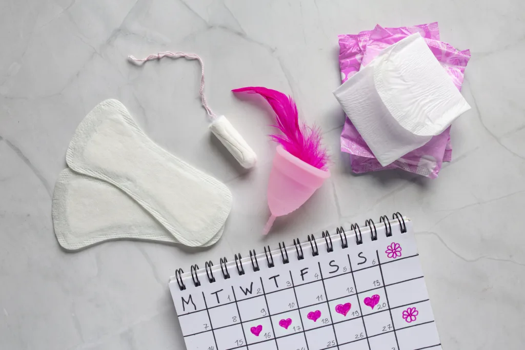 Menstruation calendar with cotton tampons. Woman hygiene protection. Woman critical days. Set of women's means personal hygiene, feminine hygiene pads, cup, menstruation