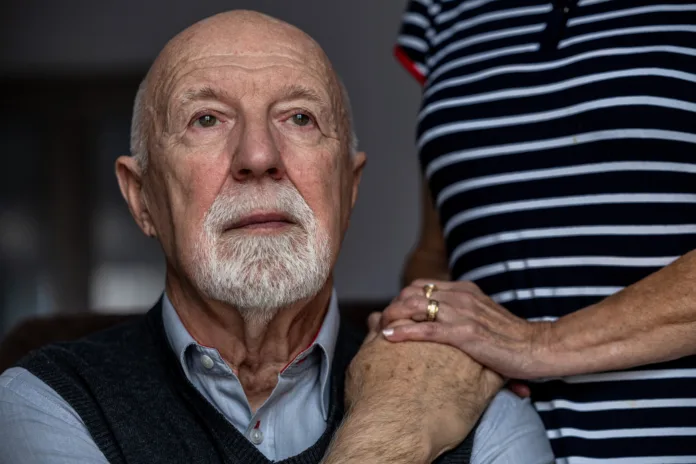 Portrait of a senior man with his caregiver in the background