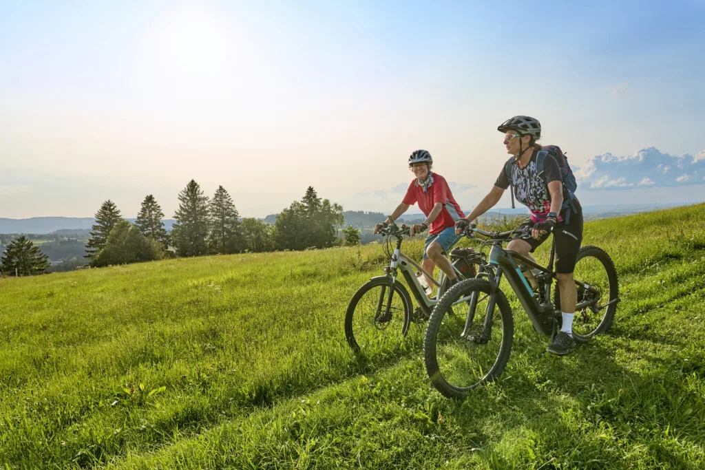 two senior girlfriends having fun during a cycling tour in the Allgau Alps near Oberstaufen, Bavaria, Germany