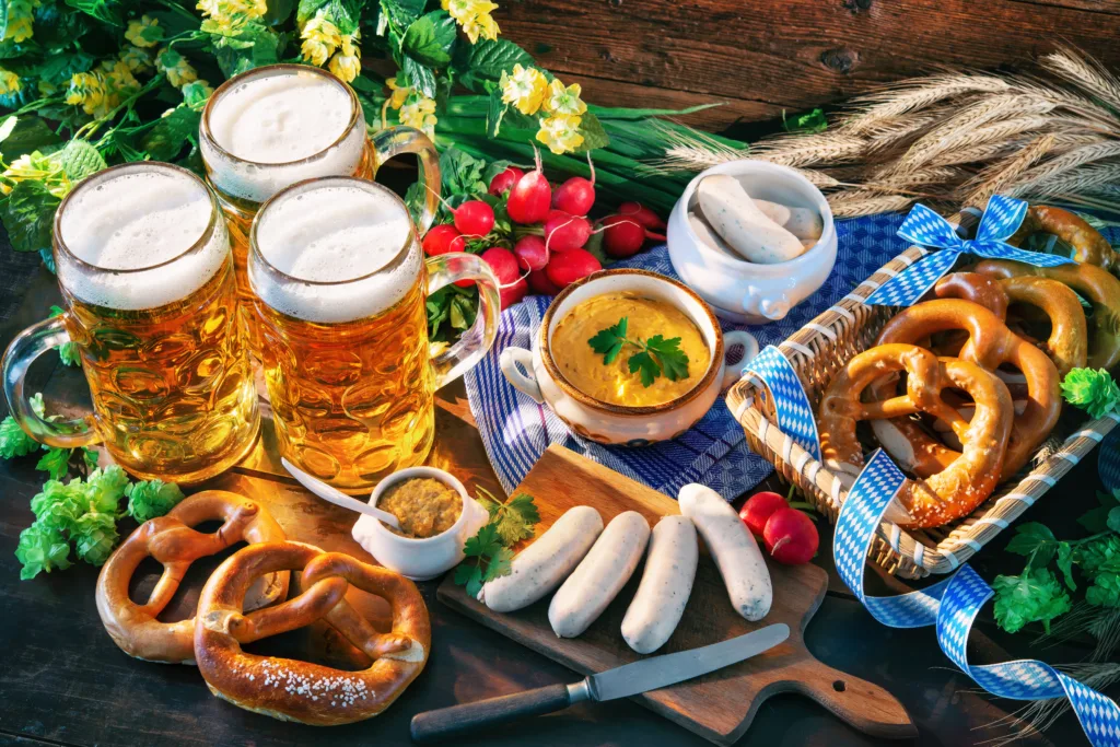 Bavarian sausages with pretzels, sweet mustard and beer mugs on rustic wooden table. Beer Fest menu