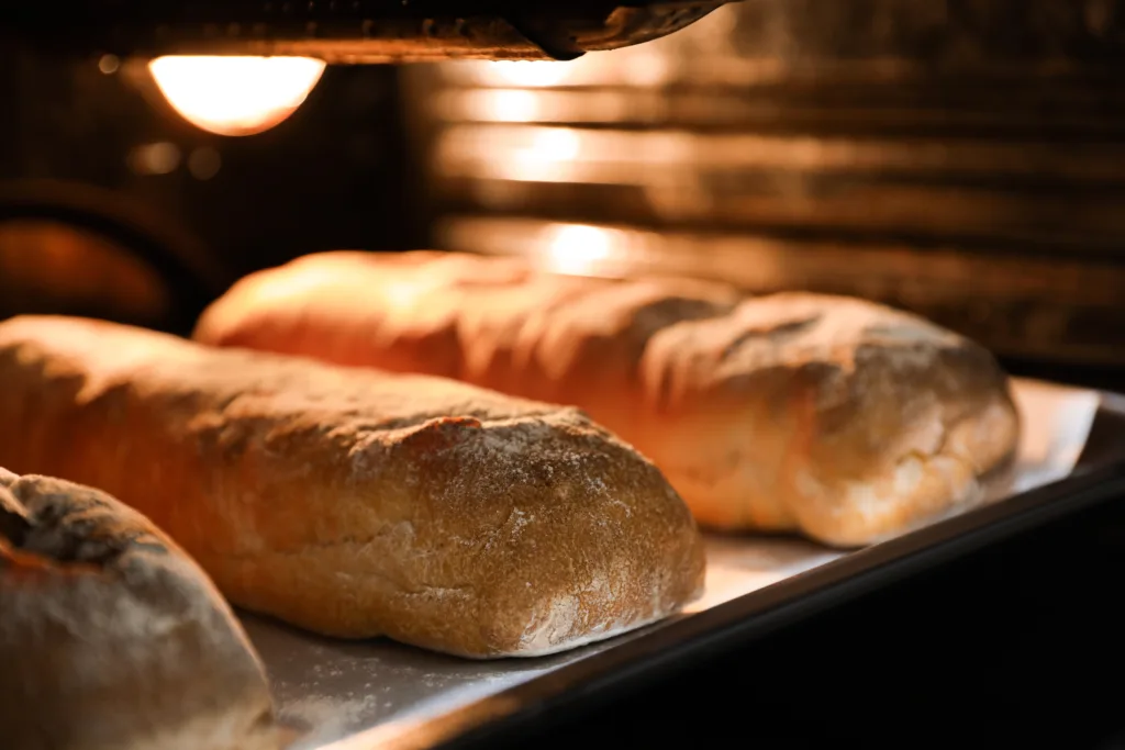 Cooking fresh crispy ciabattas in oven, closeup