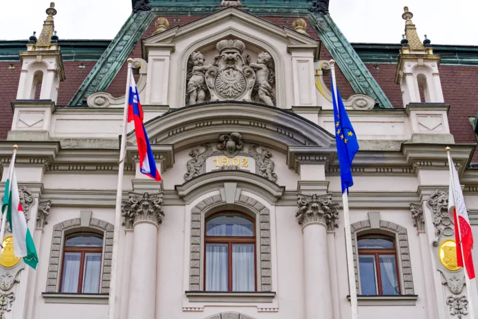 Facade of university building at the old town of City of Ljubljana with flags on a cloudy summer day. Photo taken August 9th, 2023, Ljubljana, Slovenia.