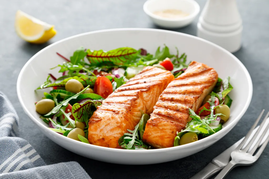 Grilled salmon fillet and fresh vegetable salad. Mediterranean diet.