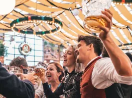 Munich, Germany – September 18, 2022: People enjoying Oktoberfest in Munich. Many visitors to largest folk festival and beer festival in the world.