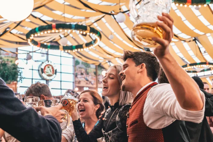 Munich, Germany – September 18, 2022: People enjoying Oktoberfest in Munich. Many visitors to largest folk festival and beer festival in the world.