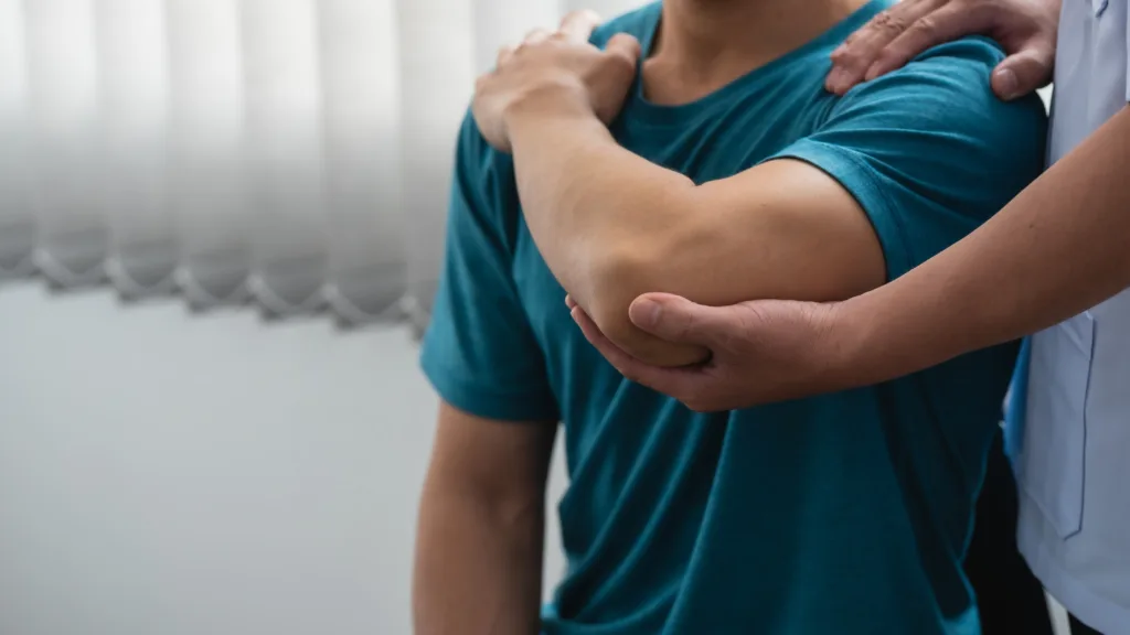 Physiotherapist assisting patient with arm rehabilitation. Healthcare and physical therapy concept