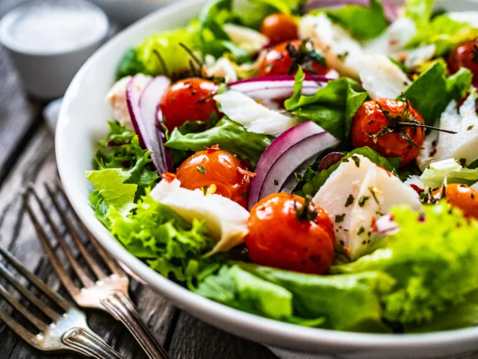 Roast cod and vegetable salad  on wooden background