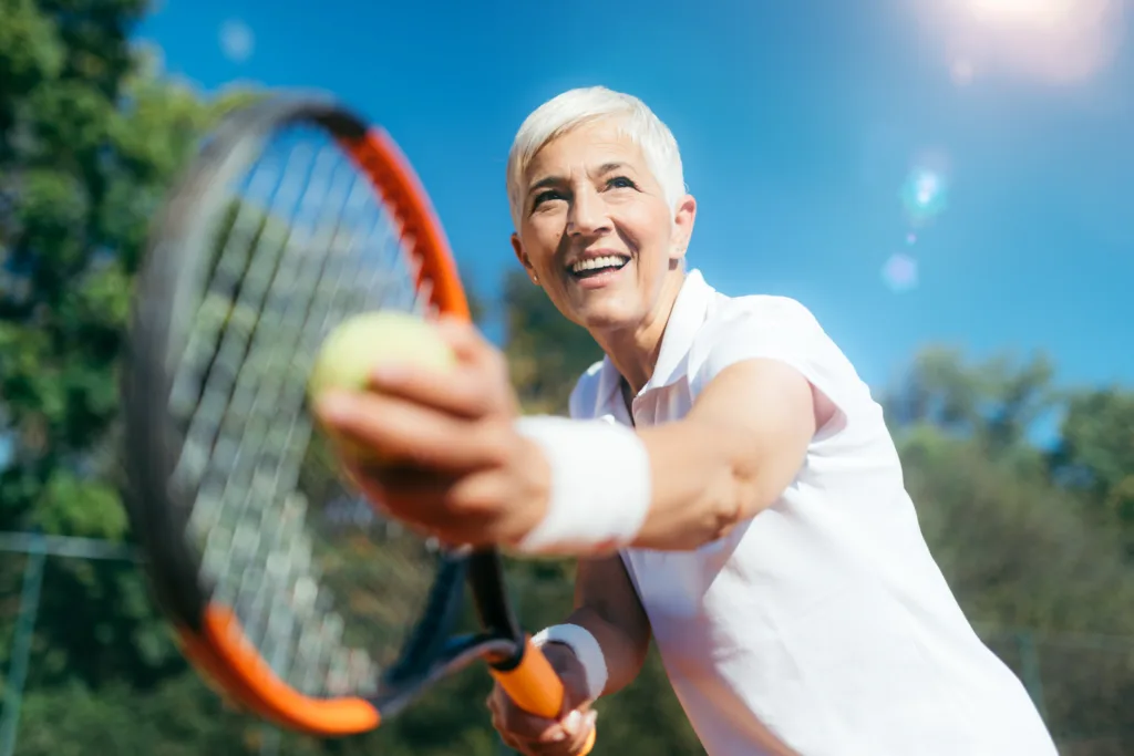 Smiling Elderly Woman Playing Tennis as a Recreational Activity