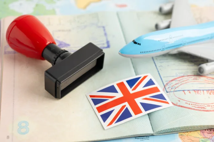 United Kingdom flag with approved Stamp visa and passport document to immigration at airport in country.