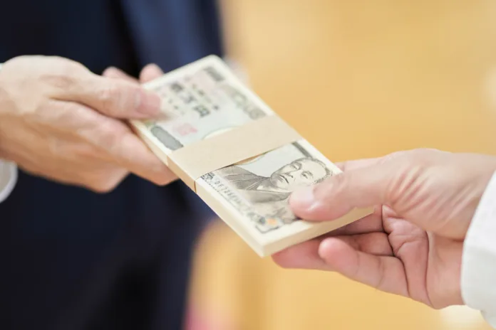 A man in a suit handing over money