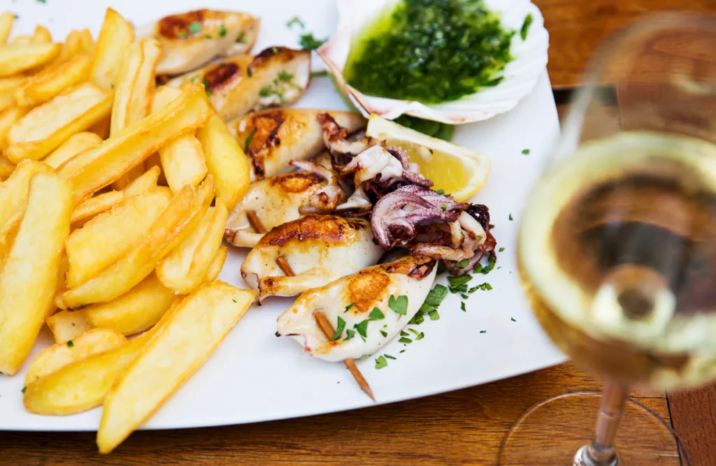 Fresh fried grill calamari stuffed with prosciutto served with fries at a restaurant in Piran, Slovenia. Slovenian, Italian, Croatian - Istrian traditional seafood dish.