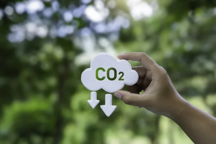 Hand holding a CO2 icon symbol. Net zero and carbon footprint for reduce emission, carbon neutral, limit climate change and global warming, and eco-friendly environment to green business