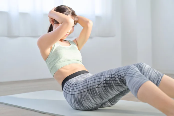 Woman training her abdominal muscles with crunches