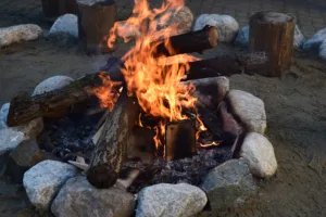 A burning fire of wood, lined with round stones. Close-up. Nikon D5300