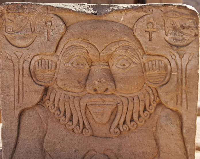 Detailed stone carving of the Egyptian God Bes,protector of households in the courtyard of  the Temple of Isis at Philae Island on Lake Nasser,built by Nectanebo and Ptolemy Pharoahs near Aswan,Egypt