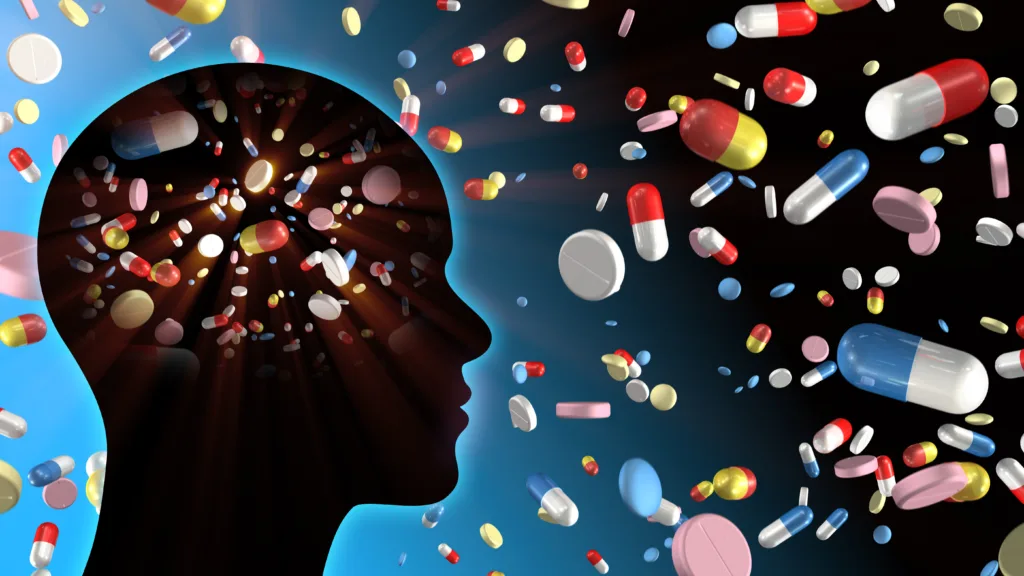 Pills and capsules in human brain head silhouette.