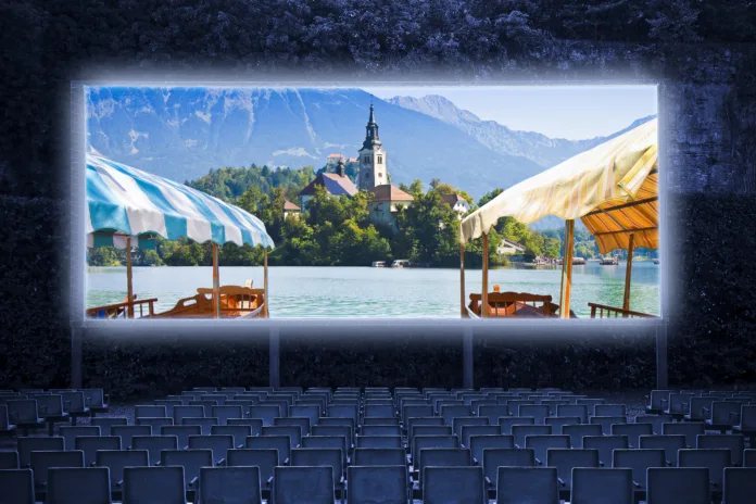 Typical wooden boats, called "Pletna", in the Bled Lake with the island of the church (Europe - Slovenia) - Outdoor cinema concept image