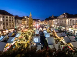 View from city hall Rathaus to Christmas market Christkindlmarkt on main square with landmark Uhrturm in Graz, Styria, Austria