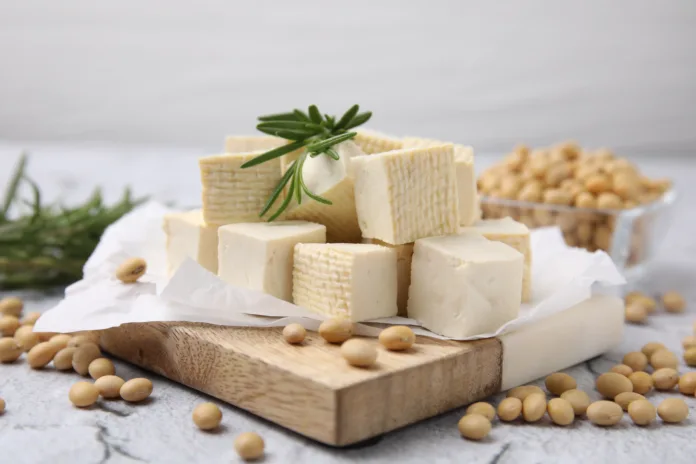 Delicious tofu cheese, rosemary and soybeans on light gray textured table, closeup