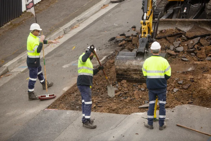 Hobart, Tasmania, Australia, September 14, 2023: View of machinery and workers repairing street surface ready to lay new bitumen on a suburban road at The Glebe, near central Hobart city