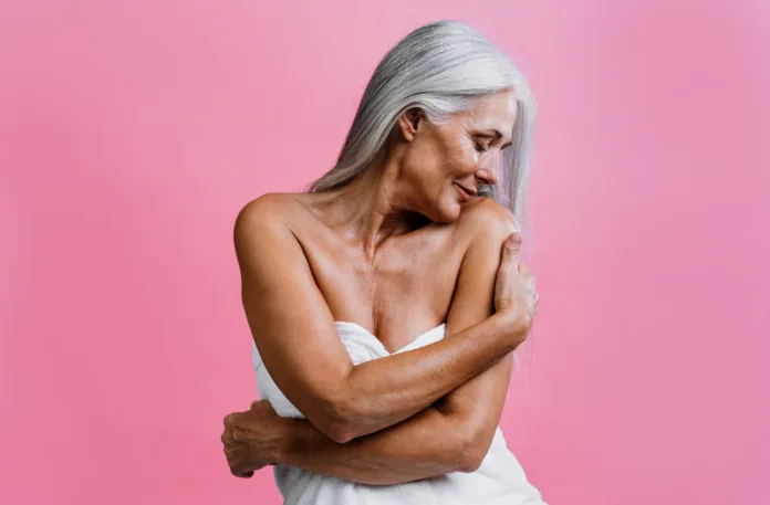 Image of a beautiful senior woman posing on a beauty photo session. Middle aged woman on a colored background. Concept about body positivity, self esteem and body acceptance