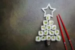 Sushi christmas tree with star over dark background, top view with copy space. Christmas or New Year background