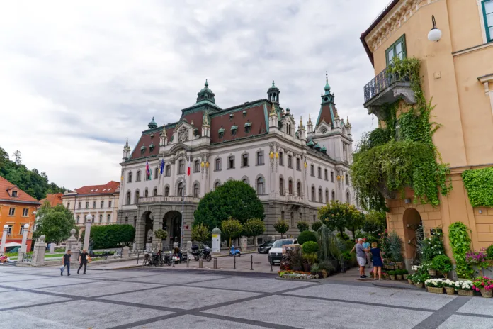 University building at the old town of City of Ljubljana with entrance and sculpture in the foreground on a cloudy summer day. Photo taken August 9th, 2023, Ljubljana, Slovenia.