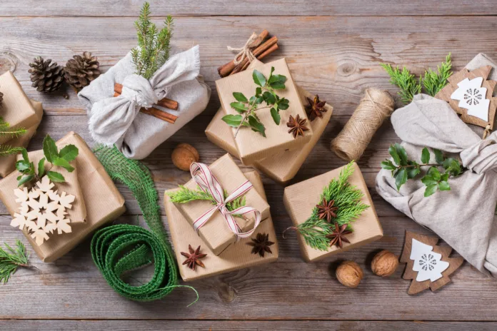 Zero waste Christmas concept. Gift boxes with handmade eco friendly craft wrapping paper and traditional Japanese style furoshiki fabric packaging. View from above