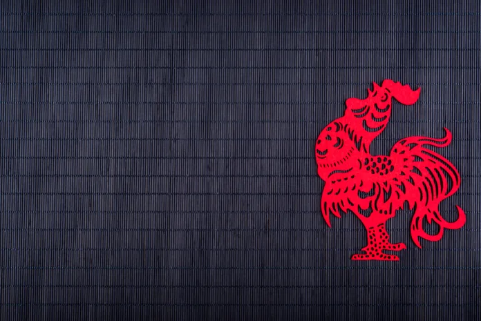 Silhouette of rooster on black bamboo mat, copy space, Chinese New Year 2017 symbol